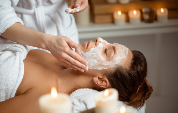 Young beautiful girl in mask for face relaxing in spa salon.